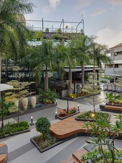 A wide-angle view of the completed university courtyard, showcasing the harmony between the hardscaped structures and the lush plantings. We used a variety of trees, including palms, to add verticality and a tropical feel to the campus.