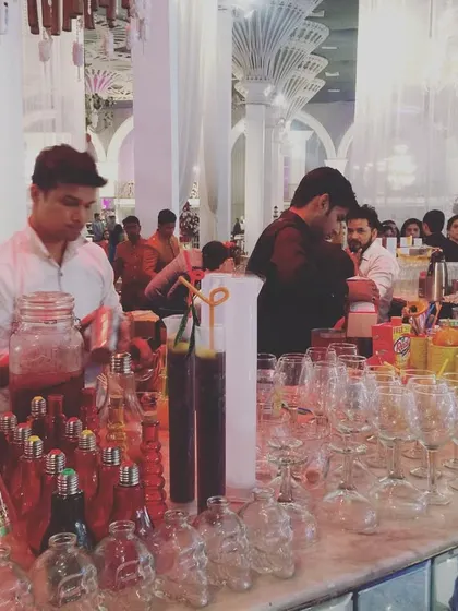 A wide shot of our beverage catering service in full swing at a large wedding venue. Our team is trained to handle high-volume events efficiently, ensuring no guest is left waiting for a drink.