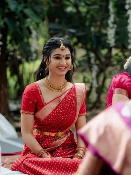 A beautiful smiling shot of Shreeja at her outdoor engagement. The natural makeup look is perfect for the daytime setting.