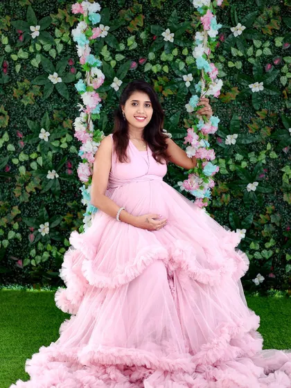 Our floral swing is a beautiful prop for creating dreamy, romantic portraits. Here, it's paired with a pink gown against a lush green wall.