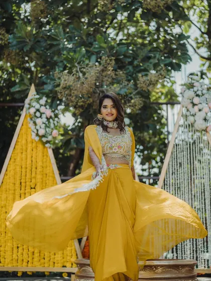 The bride twirls in her yellow outfit, perfectly complementing the vibrant Haldi decor.