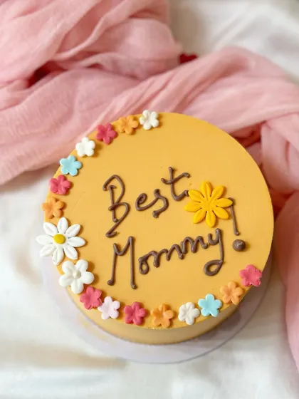A cheerful and simple cake for the "Best Mommy." This yellow cake is bordered with small, colorful buttercream flowers.