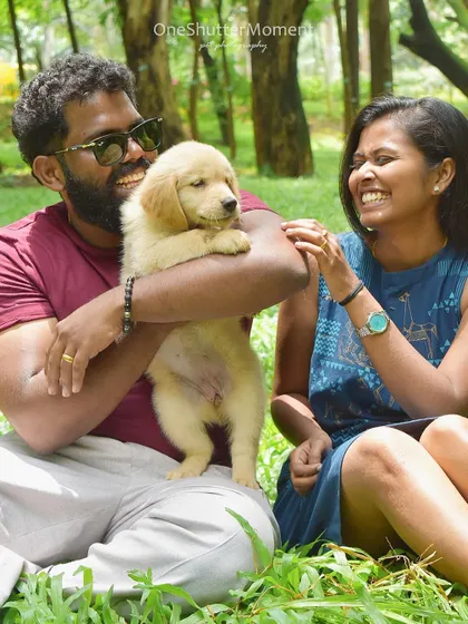 So much happiness in one frame! This couple is all smiles as they cuddle with their fluffy Golden Retriever puppy during a relaxed outdoor session.