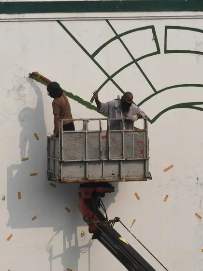 My crew and I working on the large-scale horse mural. Every big project is a collaboration, and working on a lift is part of the job when you're painting on the side of a building.