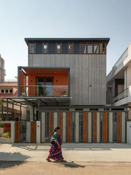 The bold facade design of the 'Chirantana' project makes it a standout in its neighborhood. The strong geometry and the striking grey and orange color palette amplify the contemporary form of this compact home.