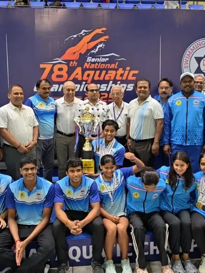 Our swimmers and coaches celebrating with the championship trophies.