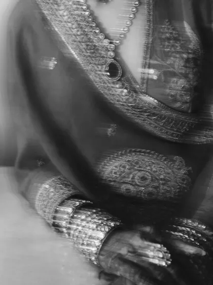 An abstract, motion-blur black and white shot focusing on the bride's attire and jewelry. This artistic technique creates a sense of movement and dreaminess.