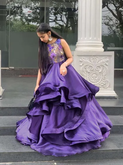 My custom design is more than a dress, it's a testament to personalized style. My delighted young client exudes beauty in this exquisite purple tiered gown with an embroidered bodice.
