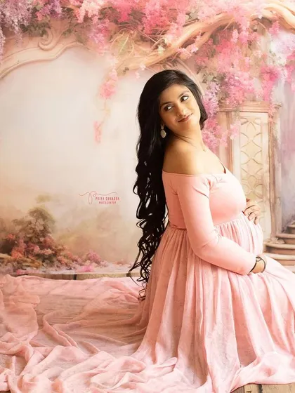 A profile shot that beautifully highlights the baby bump. The long, flowing hair and the elegant gown add to the romantic and classic feel of this portrait.