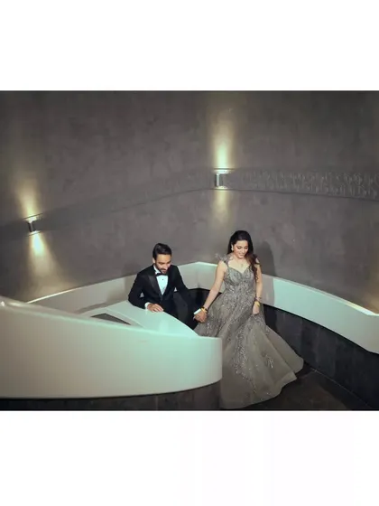 The couple making their entrance down a modern, stylish staircase. This shot has a very chic and cinematic feel.