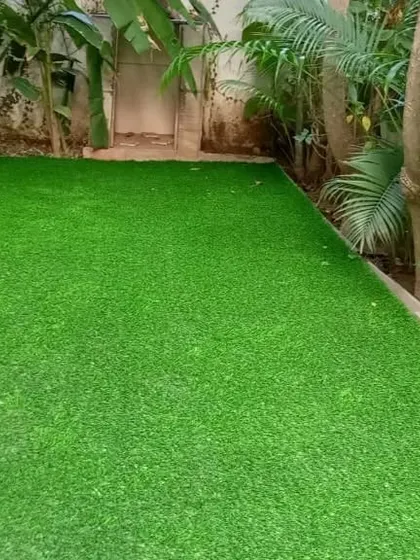 An artificial lawn installed right up to the edge of a natural garden bed. This creates a neat border and a maintenance-free area for walking or seating.