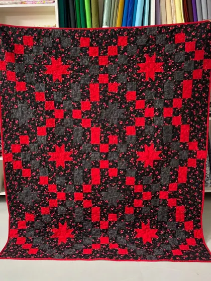 A striking red and black quilt with a "star and chain" pattern. The high contrast makes the design pop.