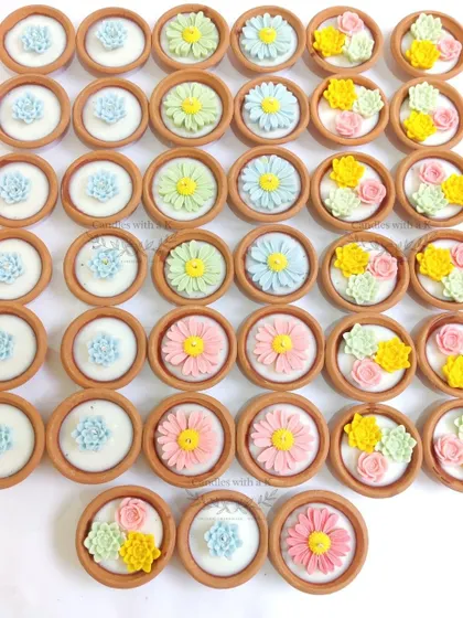 A colorful assortment of clay pot candles with daisy and succulent toppers, created as Diwali gifts for a corporate client.