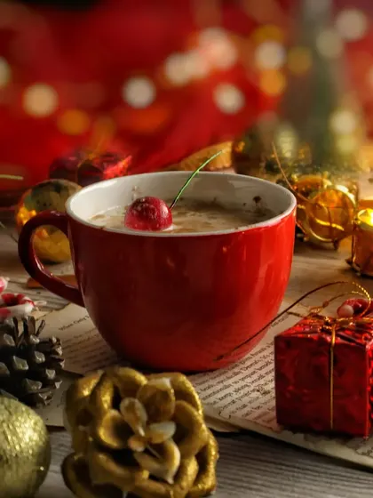 A close-up of the red Christmas mug against a background of red and gold bokeh lights. This shot is warm, magical, and full of holiday spirit.