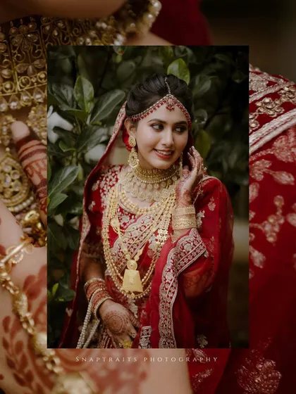 An artistic, framed portrait of the bride, her red lehenga and gold jewelry shining brightly.