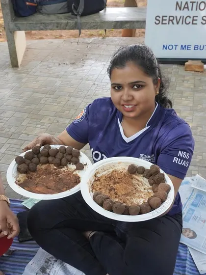 A student proudly showing off the two plates of seed balls she helped create. This activity is a great way to teach about sustainability and environmental stewardship.