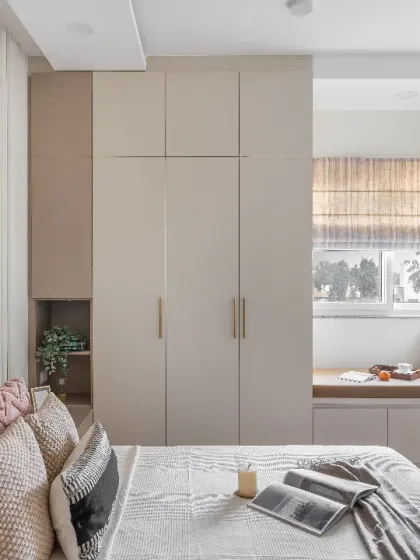 This bedroom is designed for ultimate calm and organization. The design features an integrated storage bed, matching side tables, and connecting wardrobes in a cohesive beige and taupe palette.
