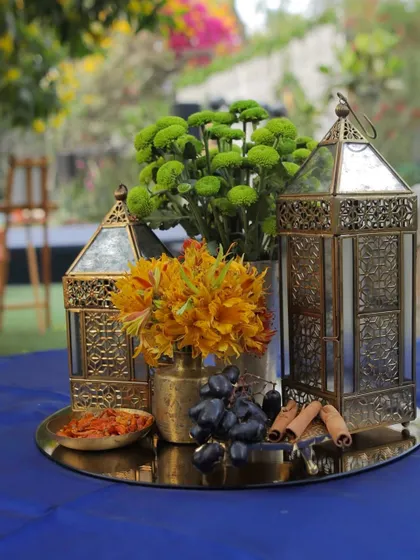 A beautiful centerpiece for a daytime event, with green chrysanthemums, grapes, and cinnamon sticks.