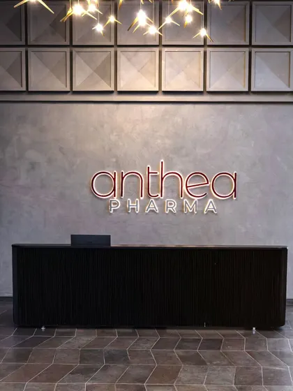 A close-up of the reception area, highlighting the custom-designed square concrete panels and the company's brightly colored logo. This detail symbolizes the blend of craftsmanship and corporate identity.