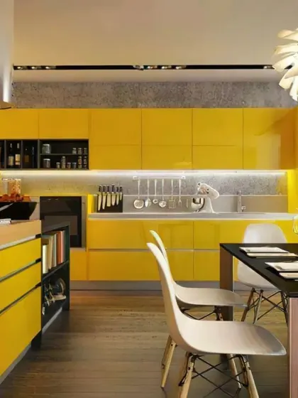A bold and vibrant kitchen design with glossy yellow cabinets and a black island. This open-plan layout integrates the kitchen with the dining area, making it a social hub.