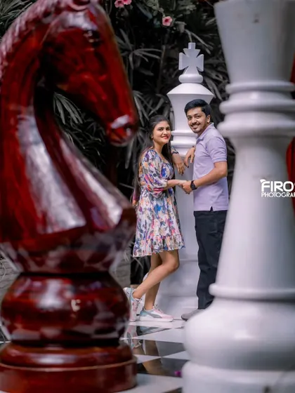 A different perspective of the couple on the giant chessboard, creating a sense of depth and scale.