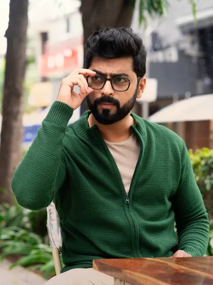 A close-up portrait of Tarak Ponnappa, using his glasses as a prop to convey an intellectual and serious character. Small details like this can add a lot of depth to a headshot.