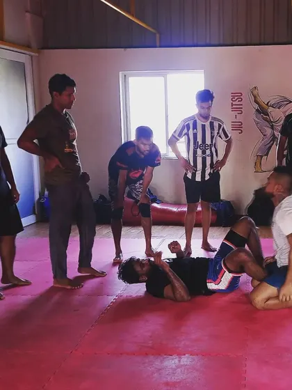 I am demonstrating a mount escape technique to the morning class. I ensure every student understands the mechanics of the move before they practice it, focusing on safety and proper form.