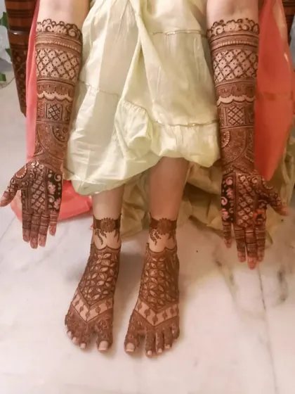 A full bridal look with matching henna on the hands and feet. The geometric patterns and intricate fills create a stunning and complete design.