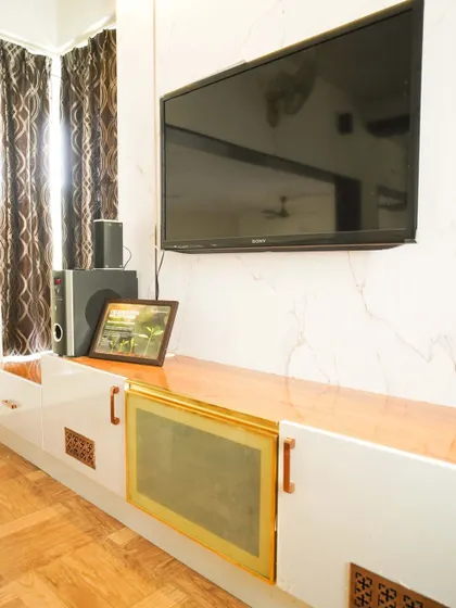 Another angle of the TV unit, highlighting the combination of white gloss, wood finish, and brass accents for a clean yet warm aesthetic.