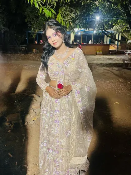 A client looking beautiful at her event in a beige lehenga with purple floral embroidery.