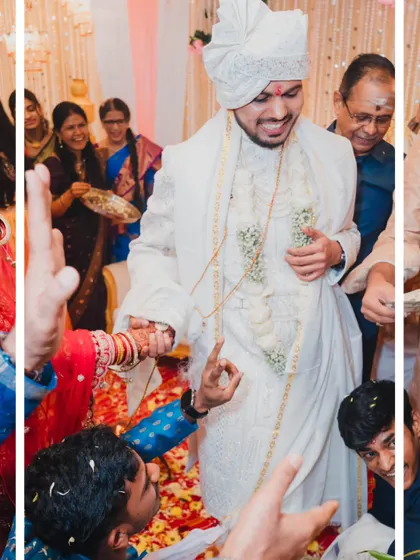 The groom's playful attempt to avoid the bride's hand during a wedding game, a fun and candid moment filled with laughter.
