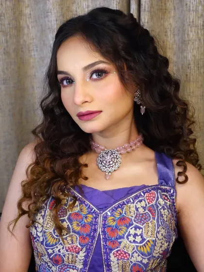 A portrait of the finished Haldi and Mehendi look. Notice the soft, curly hair and the subtle glitter on the eyes, perfect for a daytime celebration.