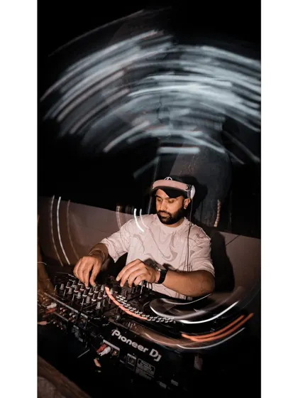 An artistic shot with light trails, showing the dynamic nature of a live DJ performance. It's all about creating movement and energy through sound.