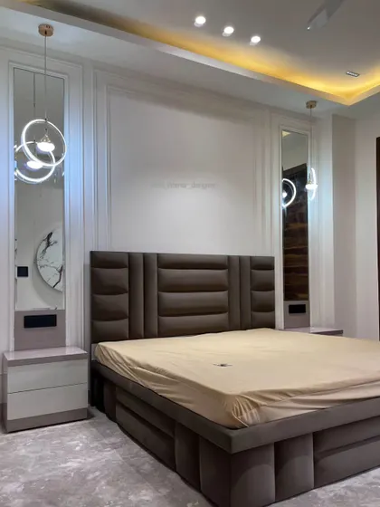 Another angle of the bedroom, highlighting the clean lines of the wall molding and the symmetry of the design. The warm cove lighting adds to the serene atmosphere.