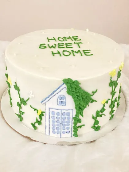 A charming "Home Sweet Home" cake, perfect for a housewarming party. This salted caramel buttercream cake is decorated with a piped illustration of a cozy house and climbing vines.