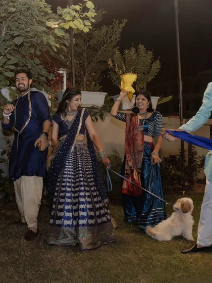 Even the dog joined the garba night. A fun, candid shot of the whole family, including their furry friend, enjoying the dance.