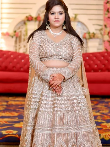 A client looking elegant in a beige lehenga for a party. The makeup is soft and subtle, with a focus on clean skin.