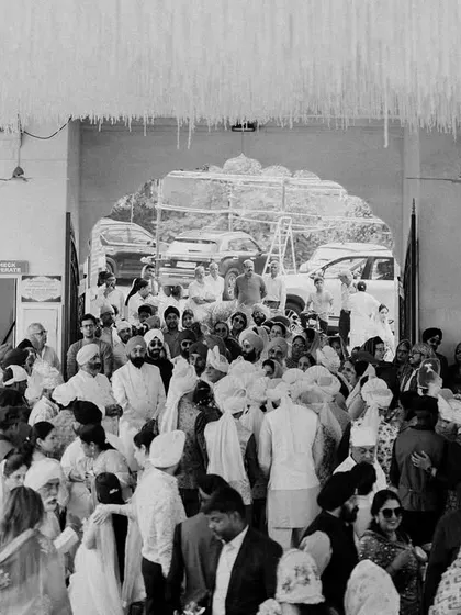 The bustling, joyful atmosphere of a Gurudwara wedding. This black and white shot captures the community and energy surrounding the couple on their special day.