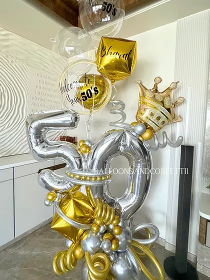 A detailed shot of the base of the 50th birthday bouquet, showing the intricate arrangement of gold and silver chrome balloons that create a luxurious foundation.