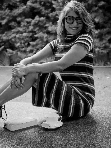 A classic black and white portrait, highlighting the timeless beauty of a simple striped dress and a happy smile.