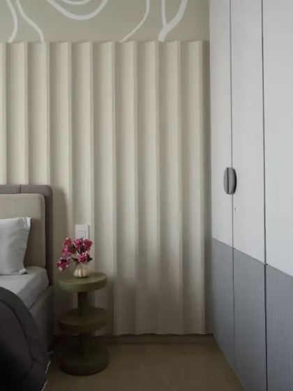 A serene and stylish kids' bedroom designed with a perfect blend of elegance and comfort. The vertical fluted wall panels create a sense of height and texture, while the abstract swirl design above adds a playful yet sophisticated touch.