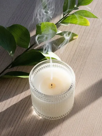 My candles are made to be enjoyed from start to finish. Here, a recently extinguished soy wax candle in a textured glass jar sends up a gentle wisp of smoke, showing the clean burn you can expect from my handmade products.