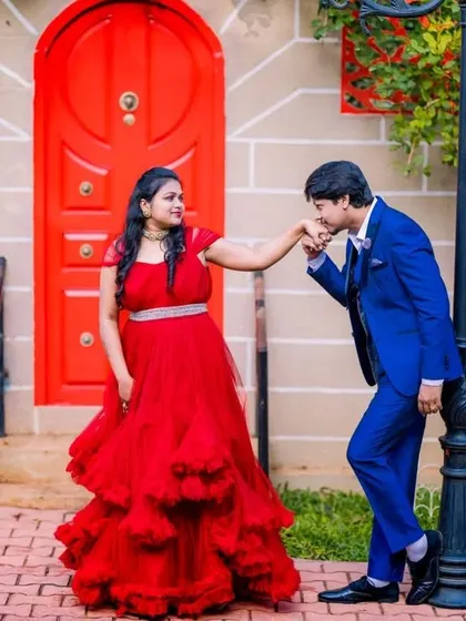A charming pre-wedding photo with a bright red door. The client's red gown and her partner's blue suit create a colorful and stylish look.