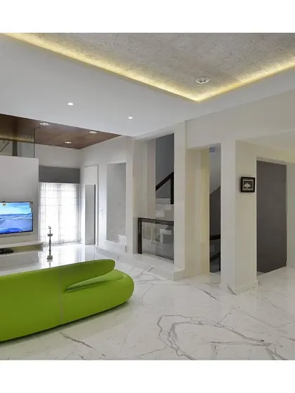 An all-white living room is given a playful and modern twist with a single, vibrant green sofa. This pop of color acts as a focal point, proving that minimalism can be both serene and fun.