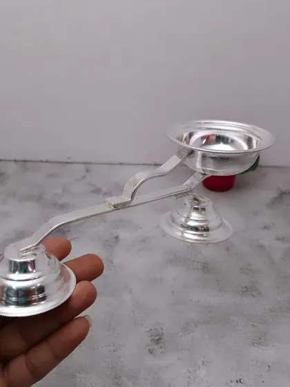 A German silver harathi stand, used for waving camphor light before the deity.