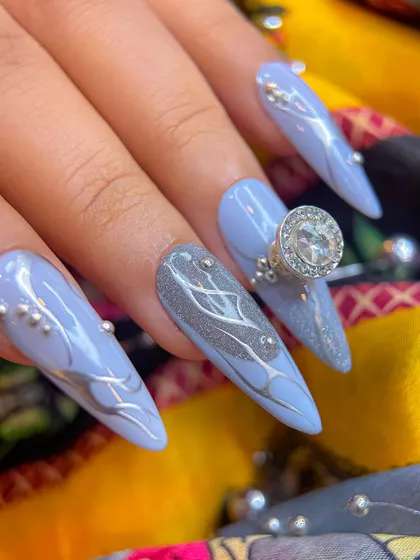 Another angle of the elegant grey Navratri nails, showing the long stiletto shape and the placement of silver beads and a large solitaire charm.