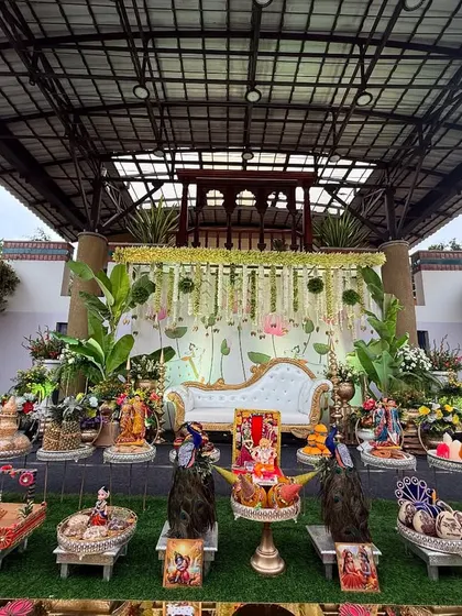 Another view of the elaborate baby shower setup, showing the stage decor with a Pichwai art backdrop and a beautiful arrangement of traditional items.