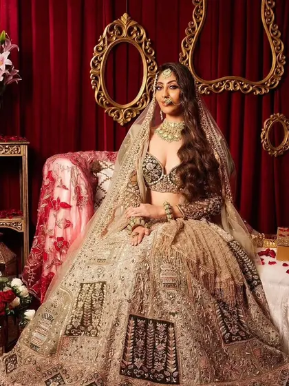 A stunning full-length shot of the bride in her elaborate lehenga. The whole look is a beautiful blend of modern style and traditional elements.