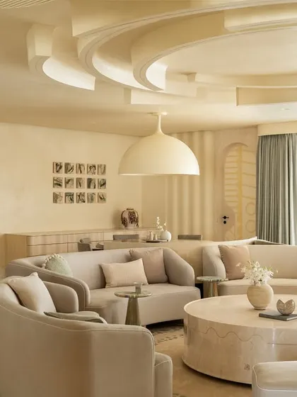 The serene and minimalist living room of the Soft Serve apartment, where soft-toned, curved sofas create a comfortable and visually cohesive conversation pit.
