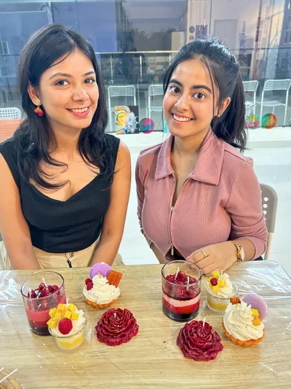 Two friends with their stunning rose and dessert candles from a Valentine's special workshop.